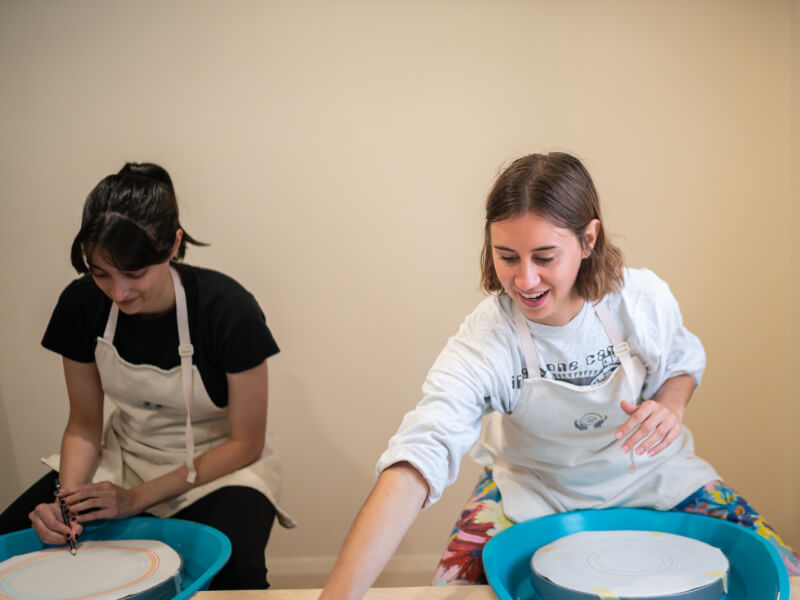 Two women making pottery at a hen party in London.
